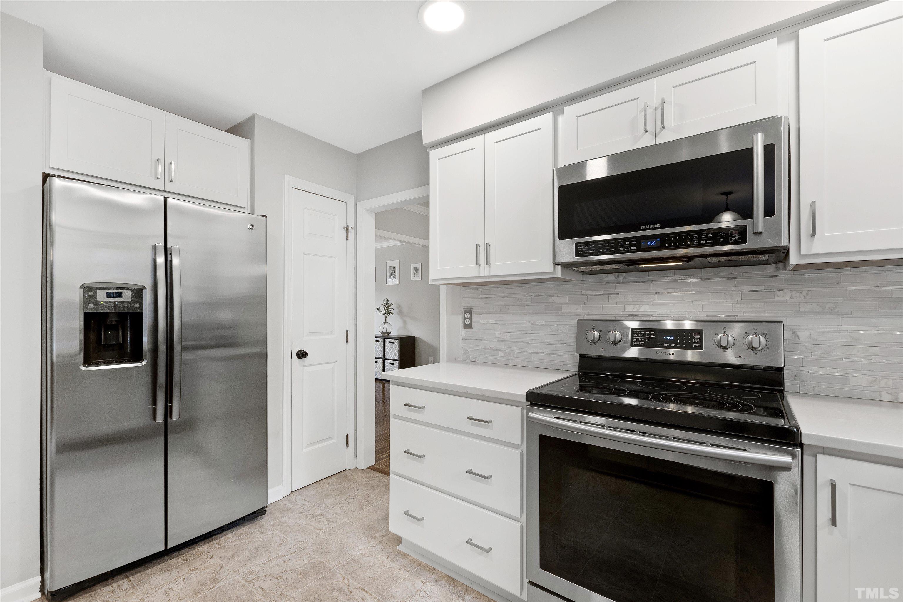 2309 Declaration Drive Raleigh, NC 27615 - Photo 12 of 30 a kitchen with stainless steel appliances a stove a microwave and a refrigerator