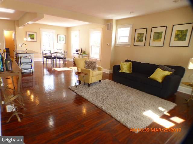 3102 Cedarhurst Road Baltimore, MD 21214 - Photo 1 of 42 a living room with couches and painting on the wall with wooden floor