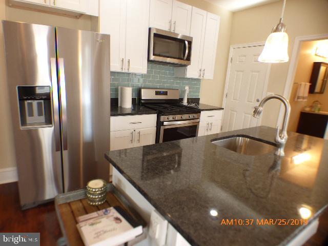 3102 Cedarhurst Road Baltimore, MD 21214 - Photo 14 of 42 a kitchen with stainless steel appliances granite countertop a sink a stove and a refrigerator