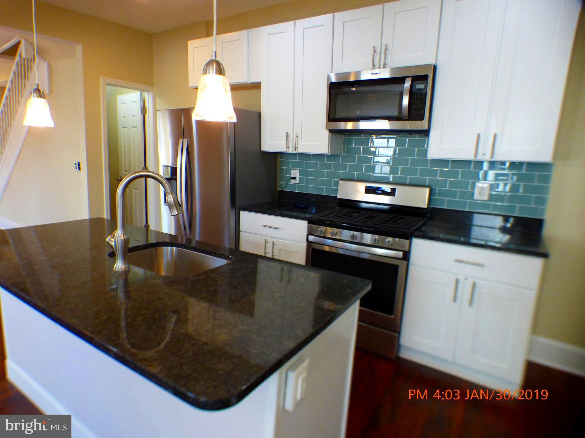 3102 Cedarhurst Road Baltimore, MD 21214 - Photo 16 of 42 a kitchen with stainless steel appliances granite countertop a sink a stove and a refrigerator