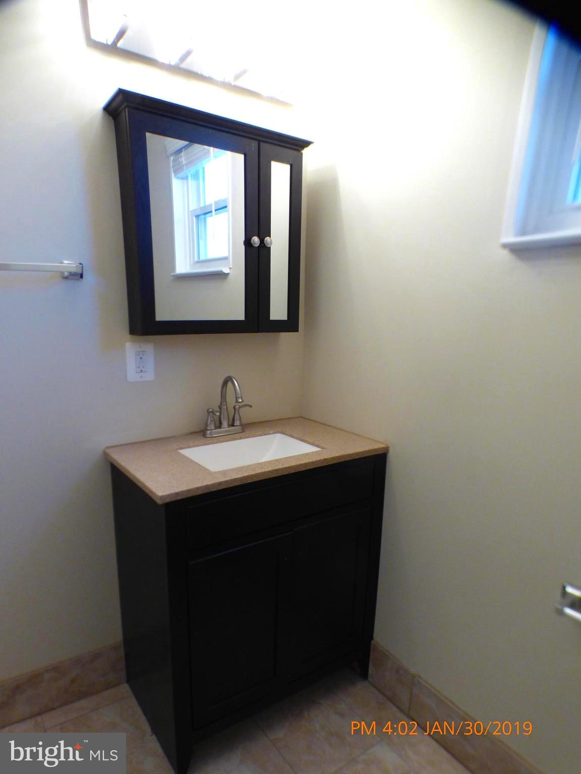 3102 Cedarhurst Road Baltimore, MD 21214 - Photo 17 of 42 a bathroom with a sink vanity and mirror