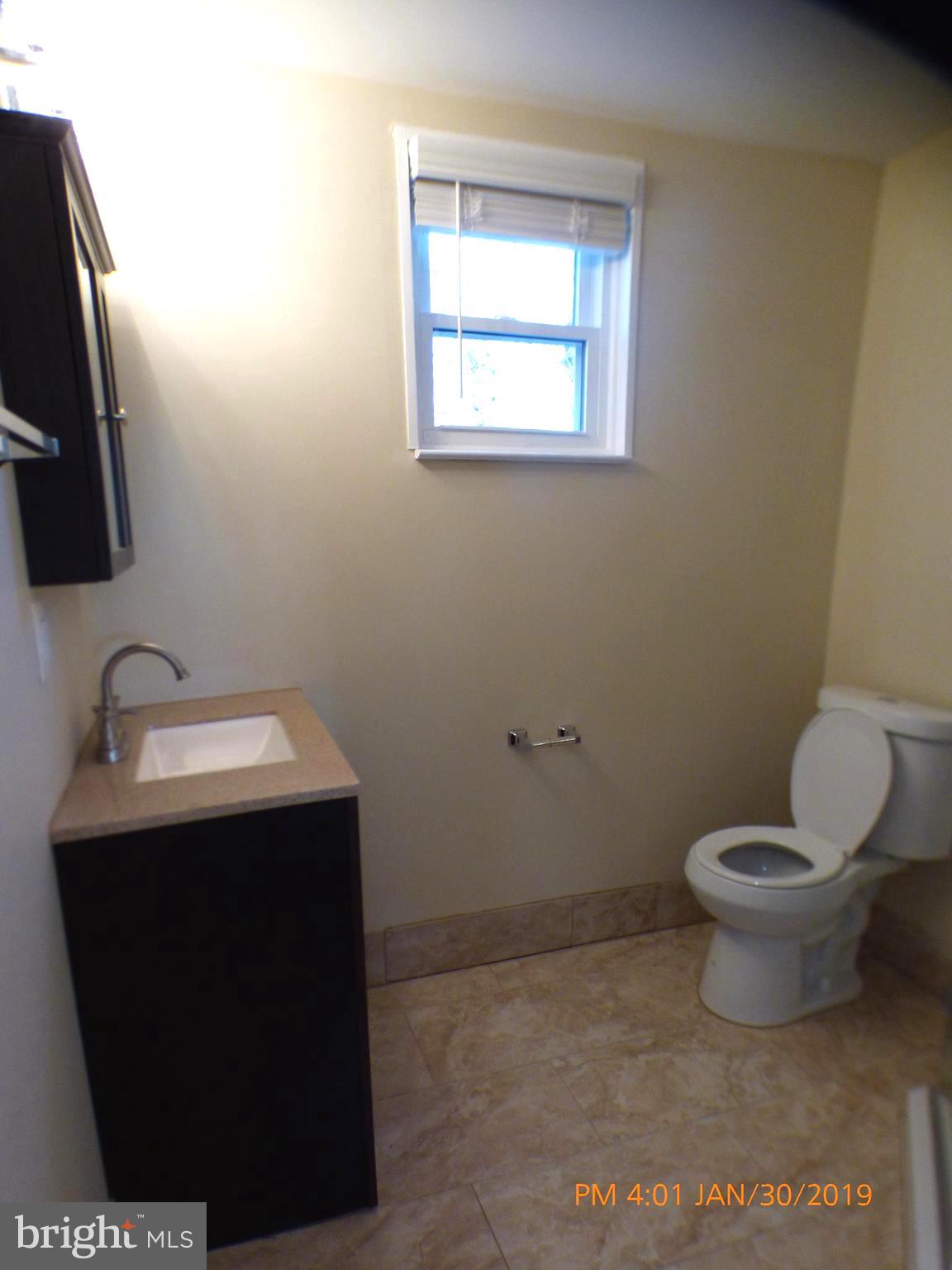 3102 Cedarhurst Road Baltimore, MD 21214 - Photo 18 of 42 a bathroom with a toilet sink and mirror