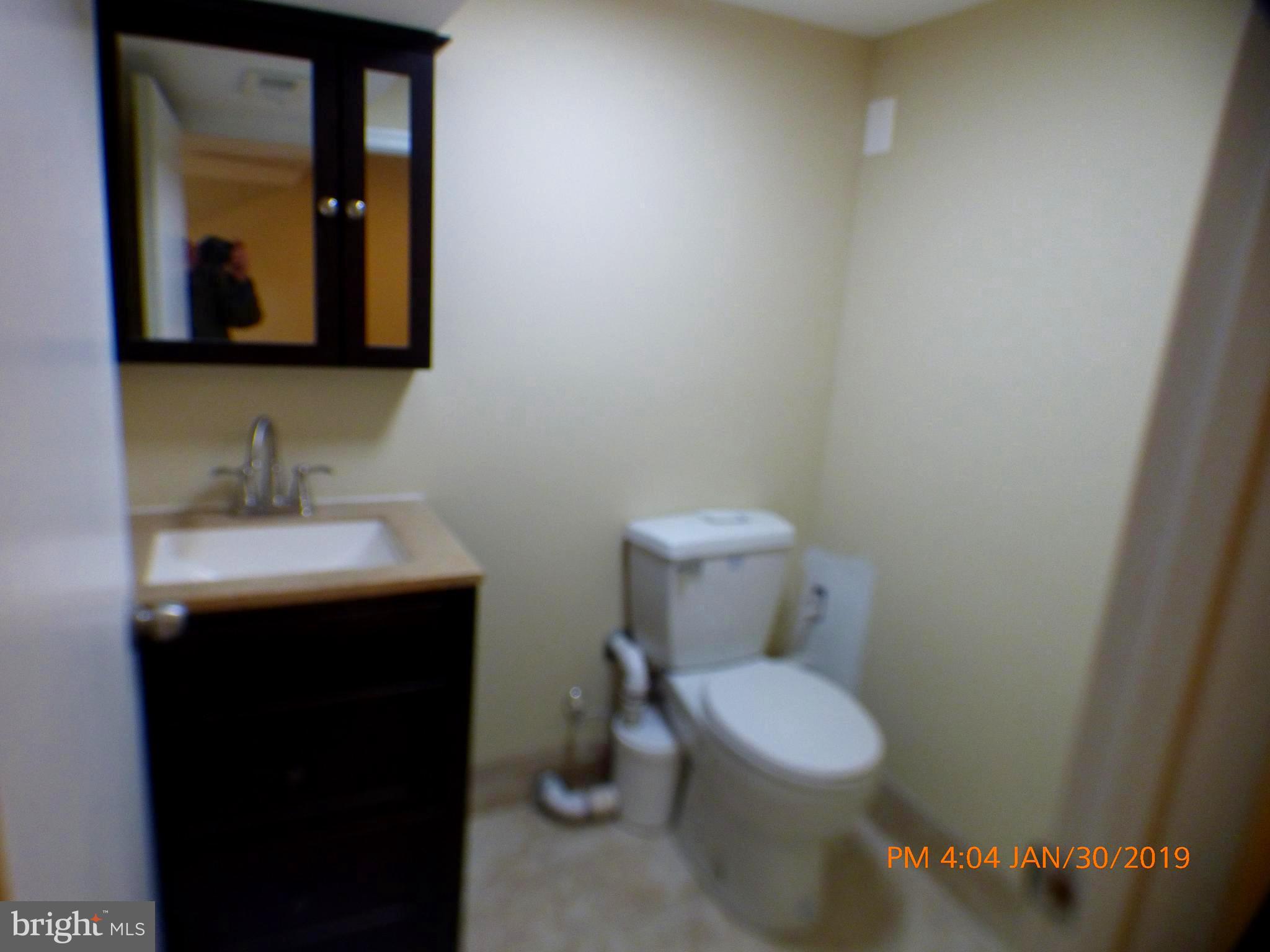 3102 Cedarhurst Road Baltimore, MD 21214 - Photo 41 of 42 a bathroom with a toilet sink and mirror