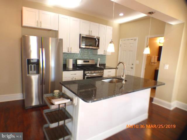 3102 Cedarhurst Road Baltimore, MD 21214 - Photo 9 of 42 a kitchen with stainless steel appliances granite countertop a sink a refrigerator and a granite counter tops