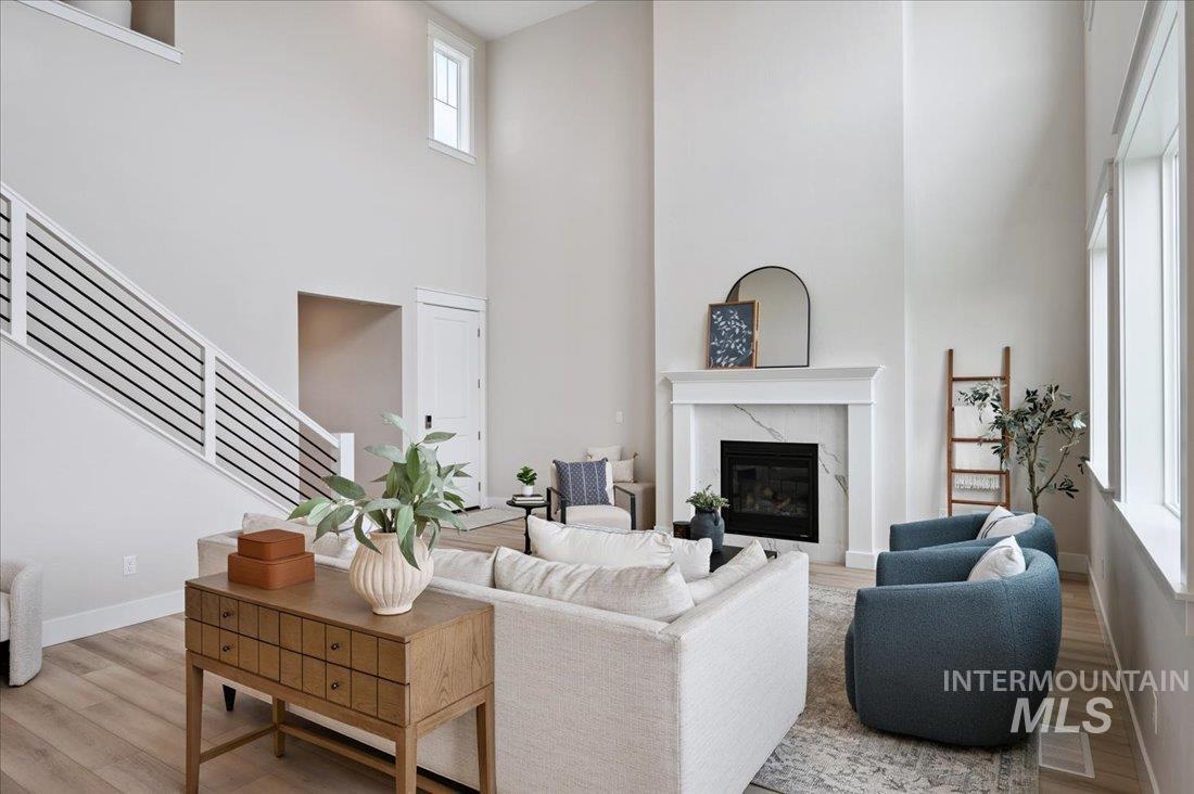6271 West Snow Currant Street Meridian, ID 83646 - Photo 2 of 14 Living room with a premium fireplace, wood finished floors, stairway, and a high ceiling