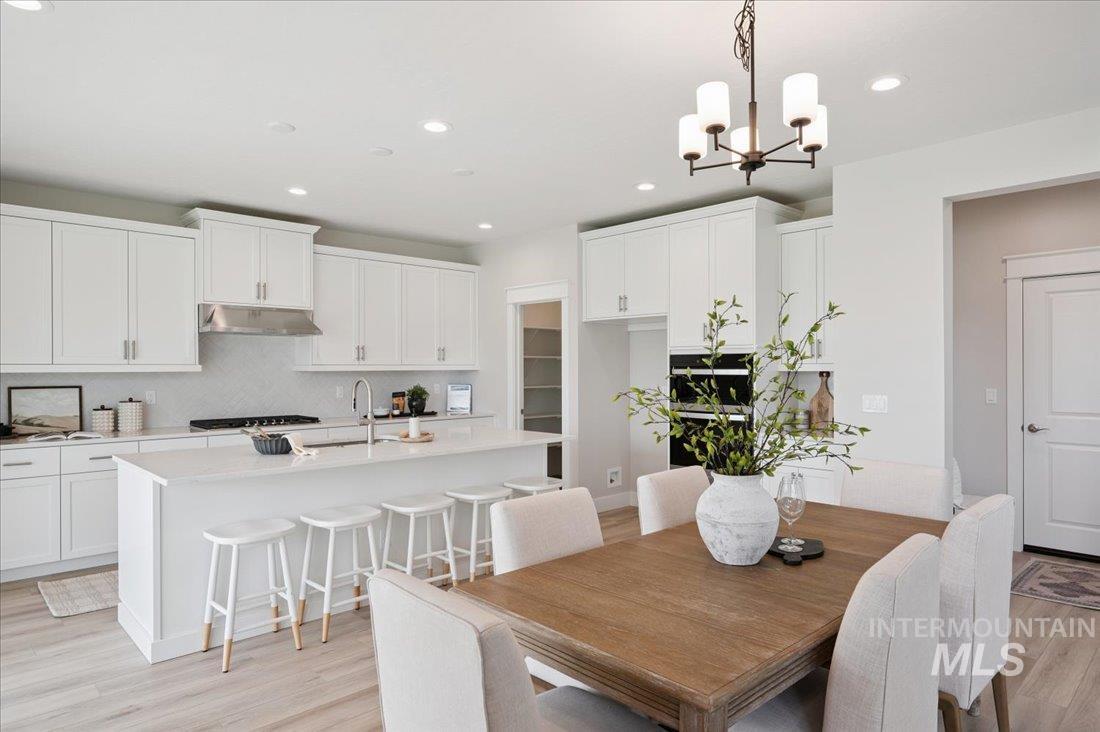 6271 West Snow Currant Street Meridian, ID 83646 - Photo 5 of 14 Dining room featuring light wood finished floors, recessed lighting, and a chandelier