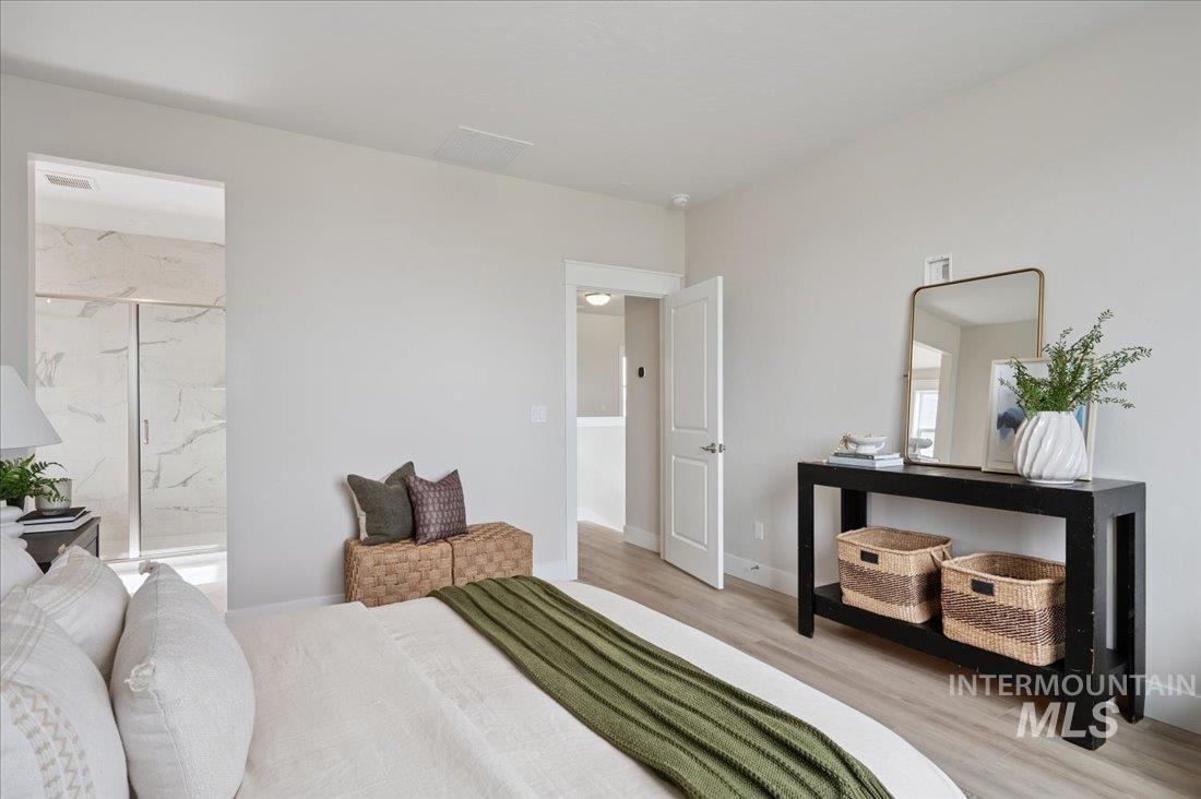 6271 West Snow Currant Street Meridian, ID 83646 - Photo 10 of 14 Bedroom featuring wood finished floors and ensuite bathroom