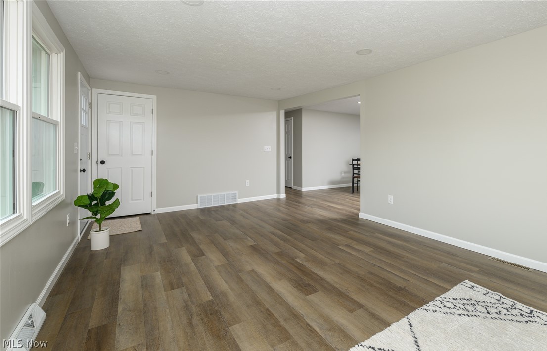 4855 4th Street Northwest Canton, OH 44708 - Photo 7 of 25 Empty room featuring plenty of natural light, dark wood-type flooring, and a textured ceiling