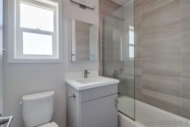 a walk in closet with wooden floor