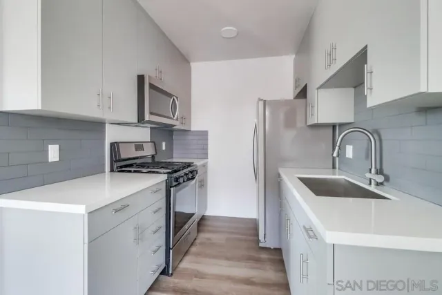 a kitchen with stainless steel appliances a sink stove and refrigerator