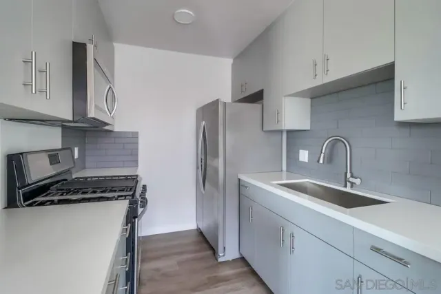 a view of kitchen with a sink and a refrigerator