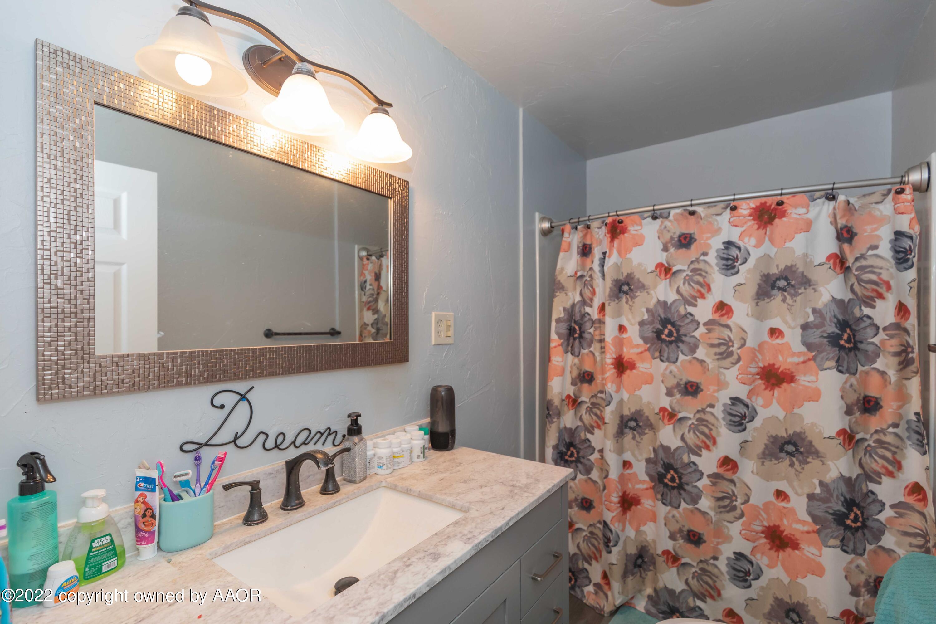 4633 South Hughes Street Amarillo, TX 79110 - Photo 5 of 23 a bathroom with a sink and a mirror