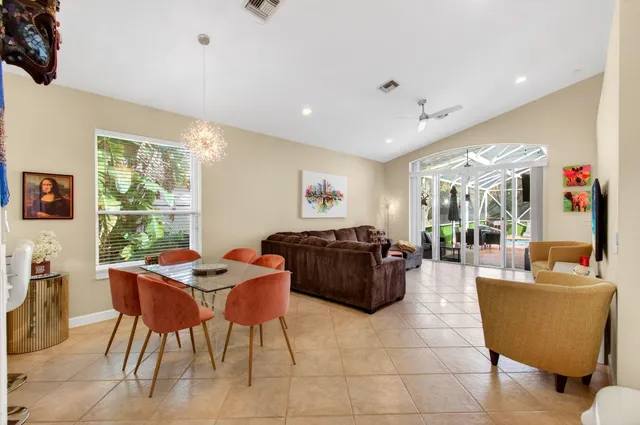 a front view of a house with garden and a tree