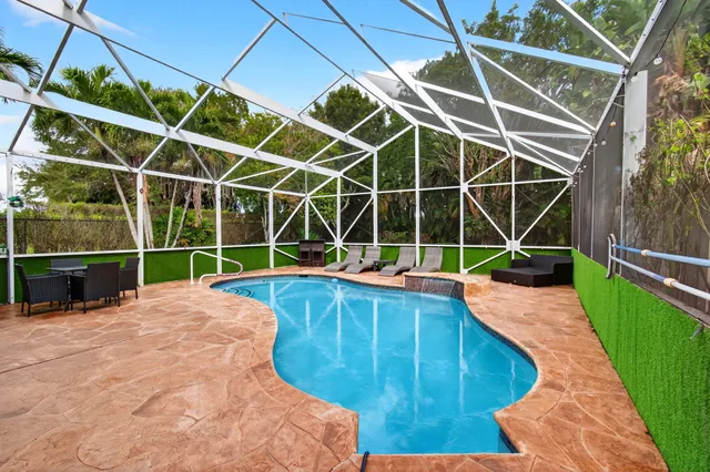 a living room with furniture a flat screen tv and a floor to ceiling window