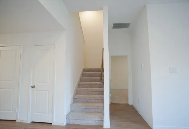 a view of a hallway with wooden floor and entryway