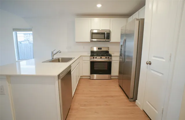 a kitchen with stainless steel appliances granite countertop a refrigerator a stove top oven a sink and dishwasher