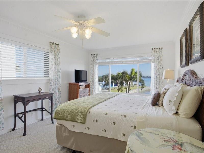 8911 Midnight Pass Road, Unit 208 Sarasota, FL 34242 - Photo 14 of 46 a bedroom with a bed and a chandelier