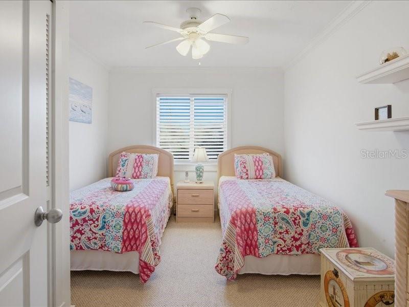 8911 Midnight Pass Road, Unit 208 Sarasota, FL 34242 - Photo 22 of 46 a bedroom with two beds and a chandelier