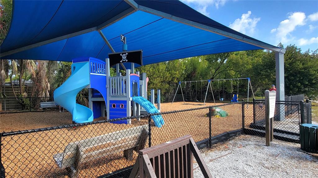 8911 Midnight Pass Road, Unit 208 Sarasota, FL 34242 - Photo 44 of 46 a view of a patio with a table and chairs under an umbrella