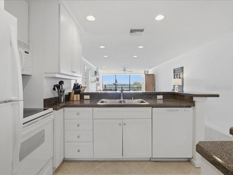 8911 Midnight Pass Road, Unit 208 Sarasota, FL 34242 - Photo 5 of 46 a kitchen with granite countertop a sink and cabinets