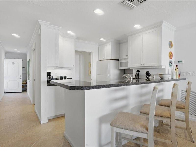 8911 Midnight Pass Road, Unit 208 Sarasota, FL 34242 - Photo 6 of 46 a kitchen with stainless steel appliances granite countertop a refrigerator and microwave