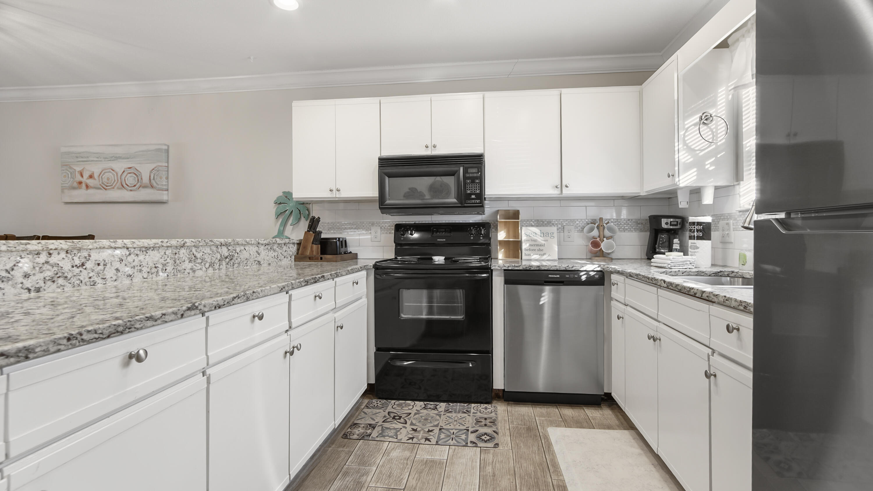 25 Misty Cove, Unit 116 Miramar Beach, FL 32550 - Photo 6 of 52 a kitchen with granite countertop a refrigerator stove and sink