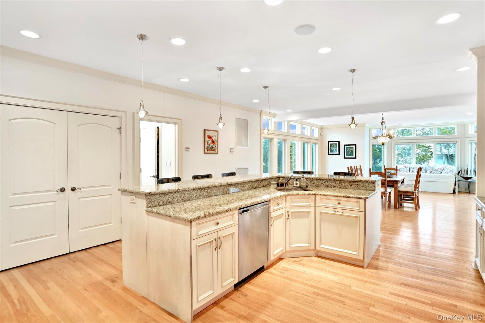 605 Dune Road Westhampton, NY 11978 - Photo 11 of 44 Kitchen island with recessed lighting, decorative light fixtures, light wood-style flooring, a center island with sink, and stainless steel Bosch dishwasher