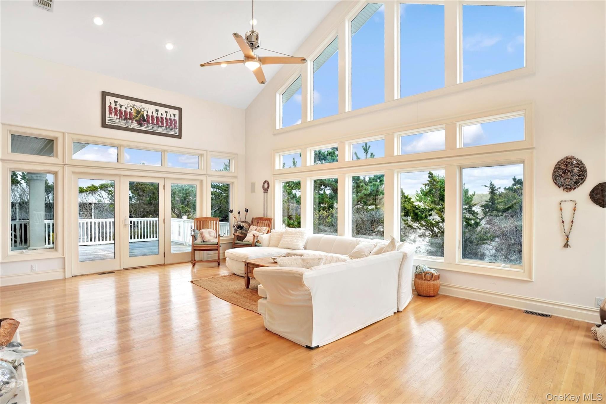 605 Dune Road Westhampton, NY 11978 - Photo 15 of 44 Living area featuring high vaulted ceiling, french doors to two decks, ight wood-style flooring, healthy amount of natural light, a ceiling fan, and recessed lighting