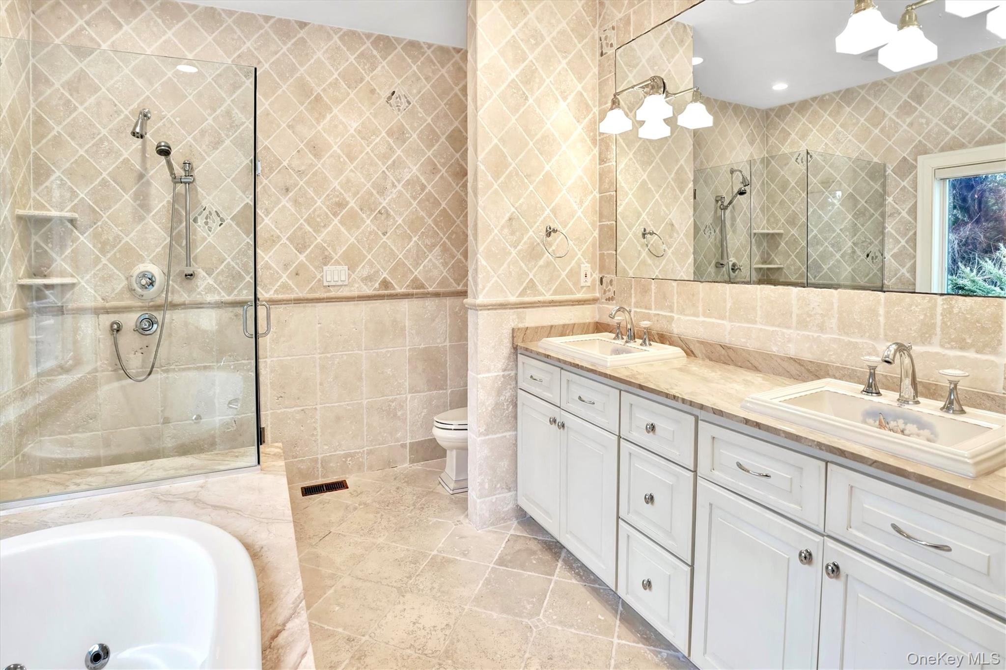 605 Dune Road Westhampton, NY 11978 - Photo 20 of 44 Full bathroom featuring tile walls, double vanity, a bathtub, a stall shower, and light tile patterned floors