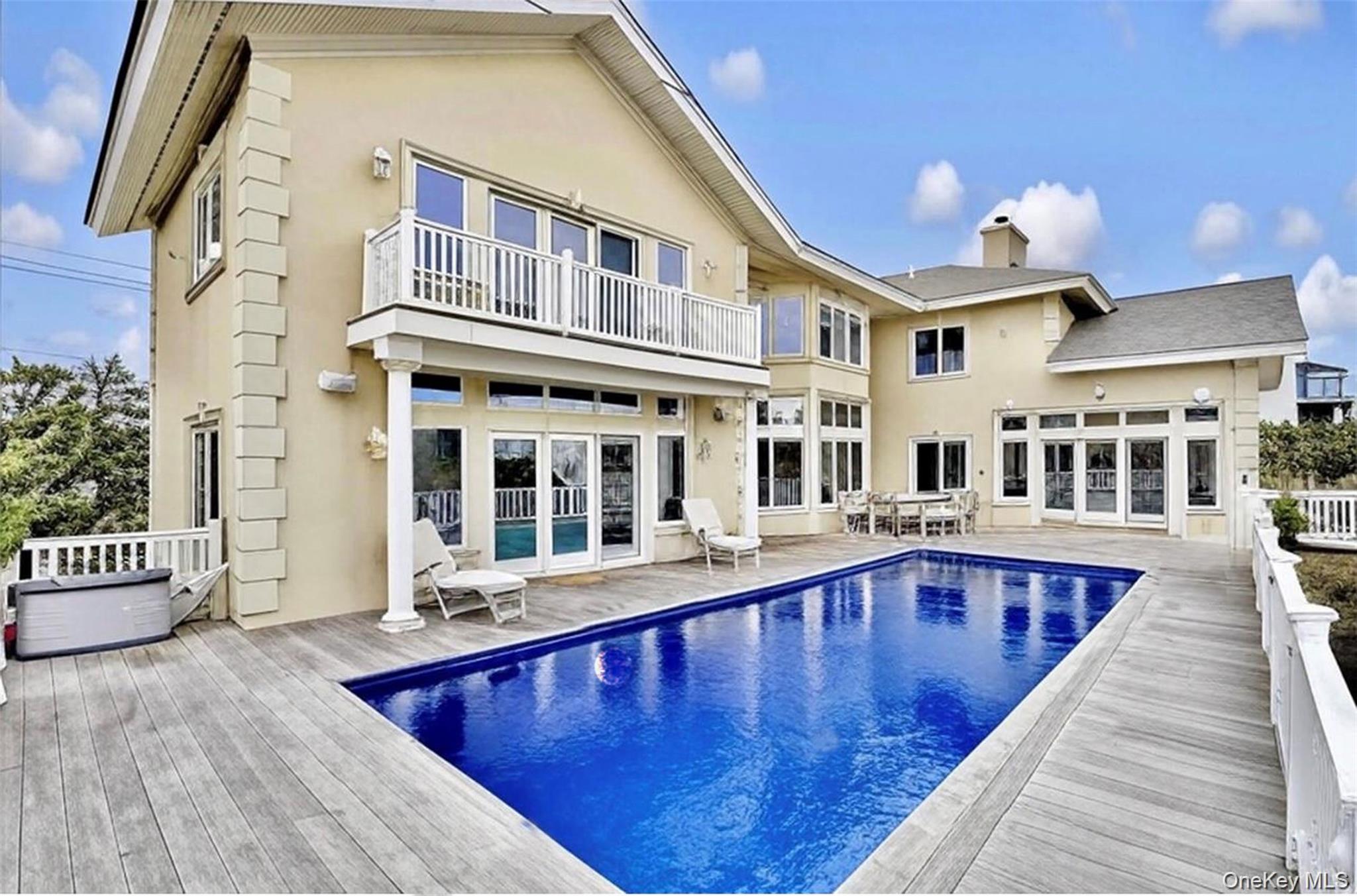 605 Dune Road Westhampton, NY 11978 - Photo 2 of 44 Back of property featuring french doors, stucco siding, a balcony, and a chimney
