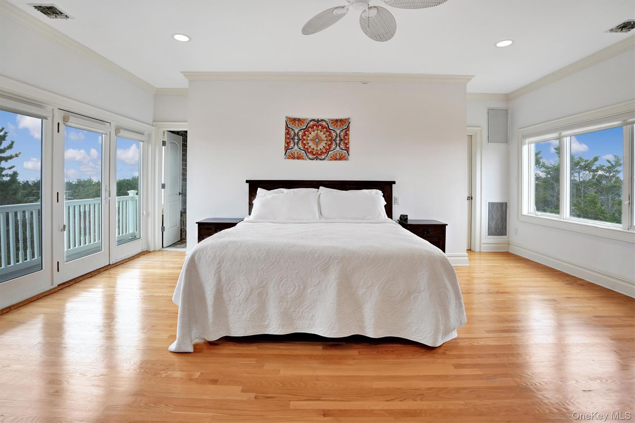 605 Dune Road Westhampton, NY 11978 - Photo 24 of 44 Second Floor Primary Bedroom with stunning ocean and bay surround views, featuring crown molding, light wood-type flooring, access to exterior, a ceiling fan, and recessed lighting