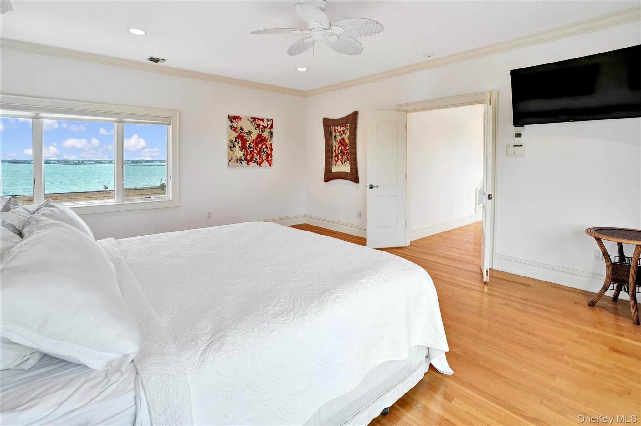 605 Dune Road Westhampton, NY 11978 - Photo 26 of 44 Second Floor Primary Bedroom with crown molding, light wood-style floors, ceiling fan, recessed lighting, and a water view