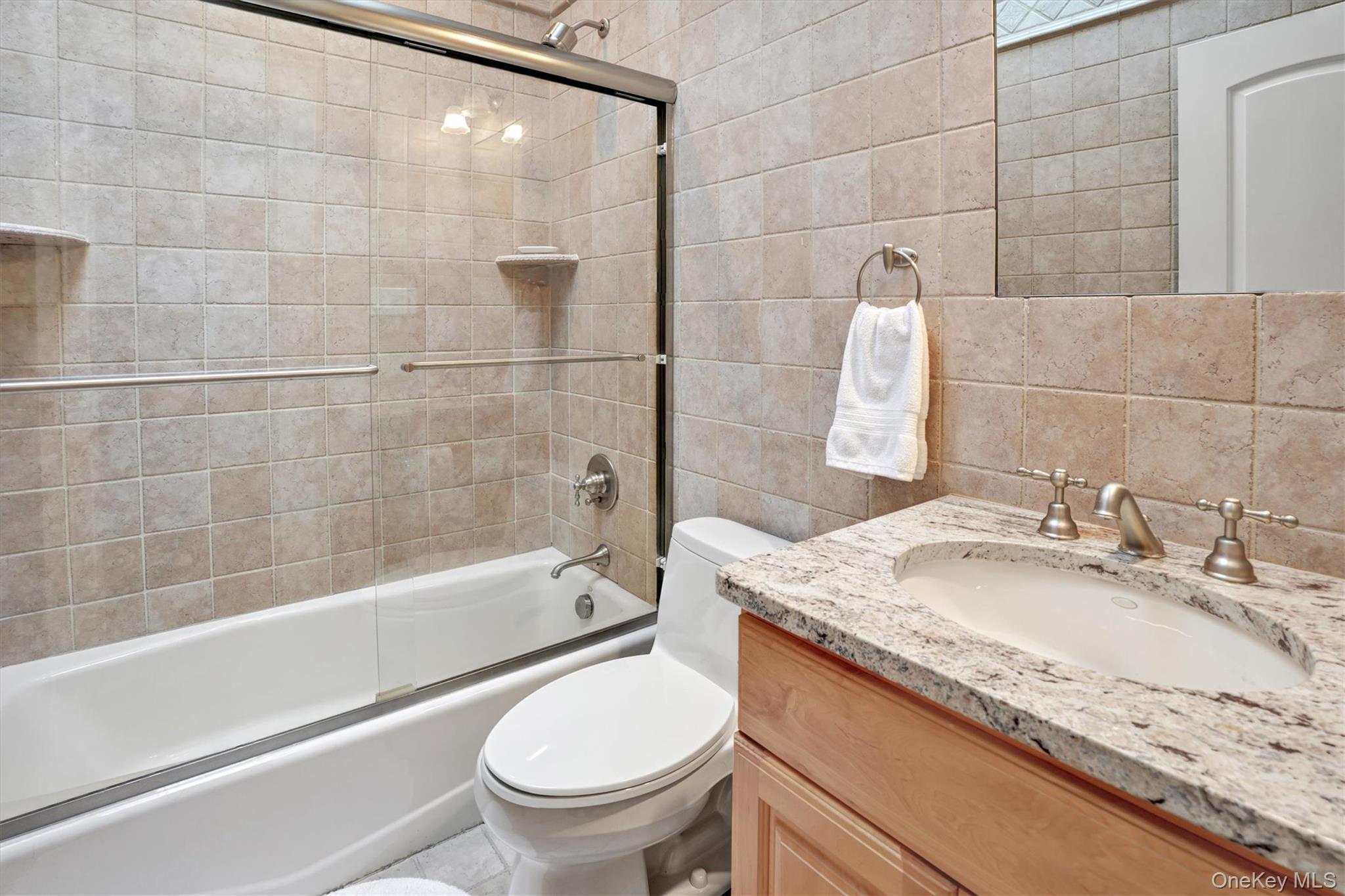605 Dune Road Westhampton, NY 11978 - Photo 36 of 44 4th Bedroom - ensuite full bathroom with vanity, tile walls, shower / bath combination with glass door, and backsplash