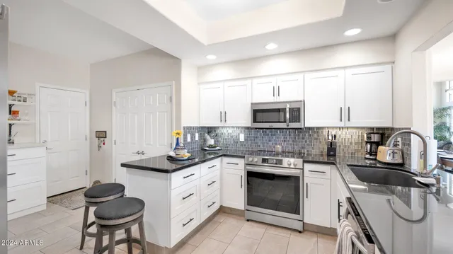 a kitchen with granite countertop a sink stove and cabinets