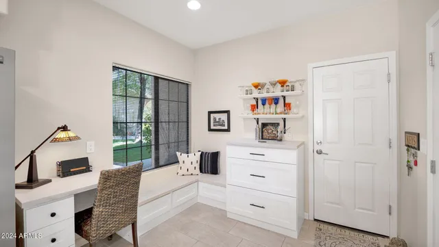a living room with furniture a baby crib and a window