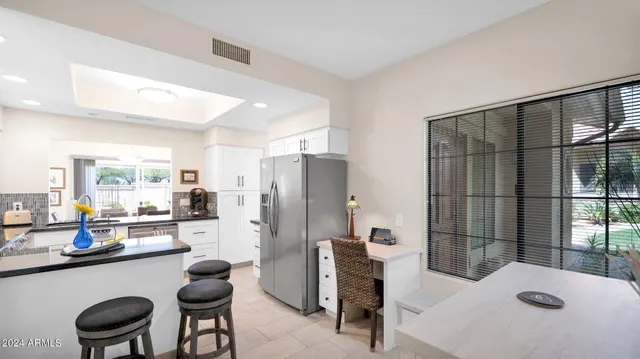 a kitchen with stainless steel appliances a dining table chairs and a refrigerator