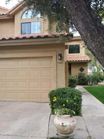 a front view of a house with a yard and a fountain