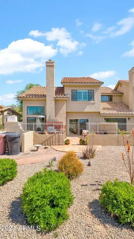 a front view of a building with a garden and pathway