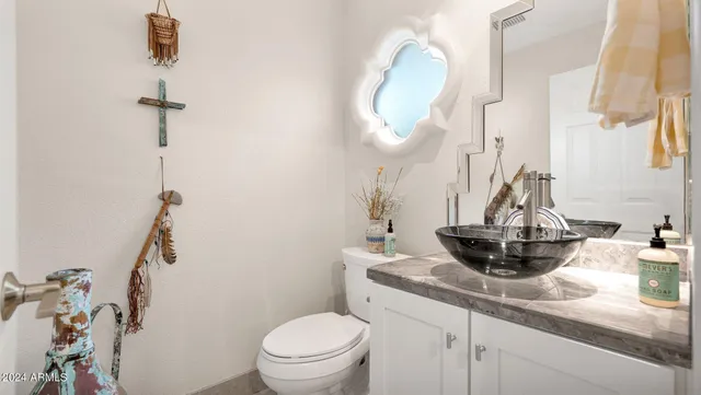 a bathroom with a sink a toilet and mirror