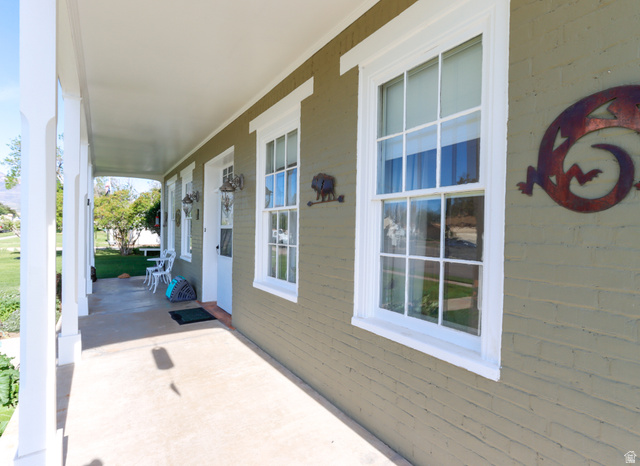 155 West Center Street Fillmore, UT 84631 - Photo 7 of 86 Covered front porch featuring a painted brick exterior, multiple double-hung windows with white trim, and a white front door