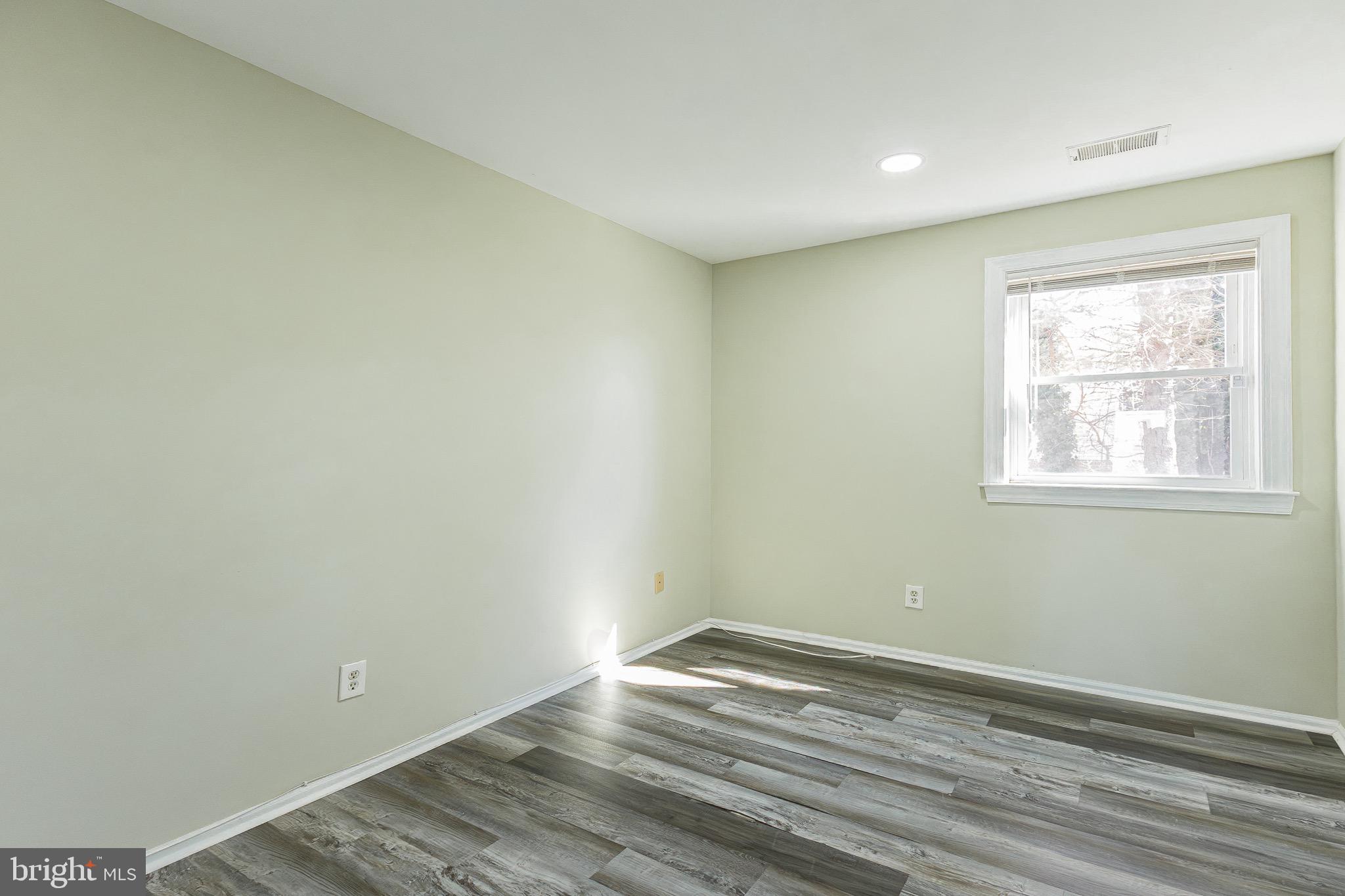 9463 Ashton Road, Unit 1 Philadelphia, PA 19114 - Photo 12 of 25 an empty room with wooden floor and windows