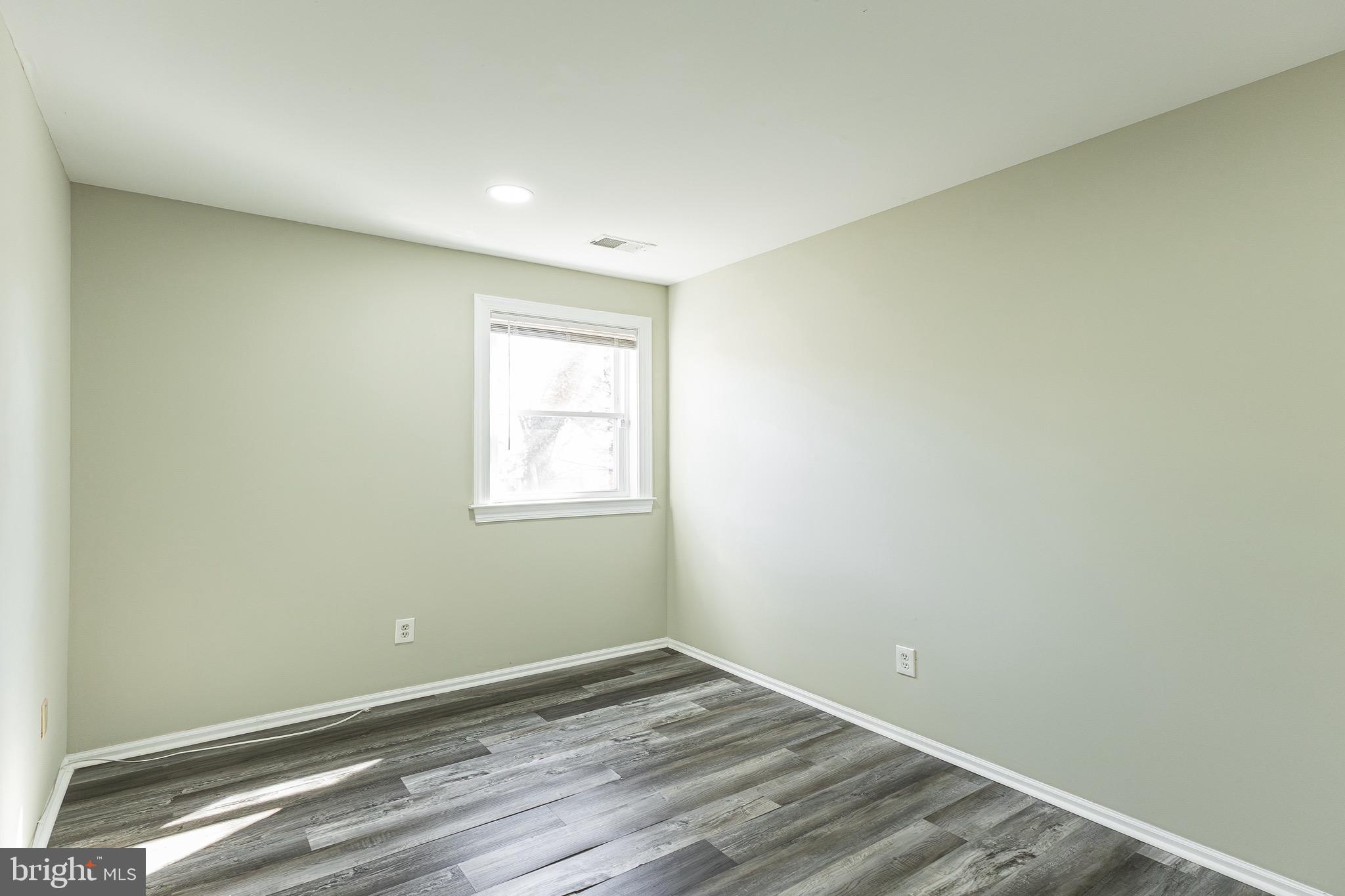 9463 Ashton Road, Unit 1 Philadelphia, PA 19114 - Photo 16 of 25 an empty room with wooden floor and windows