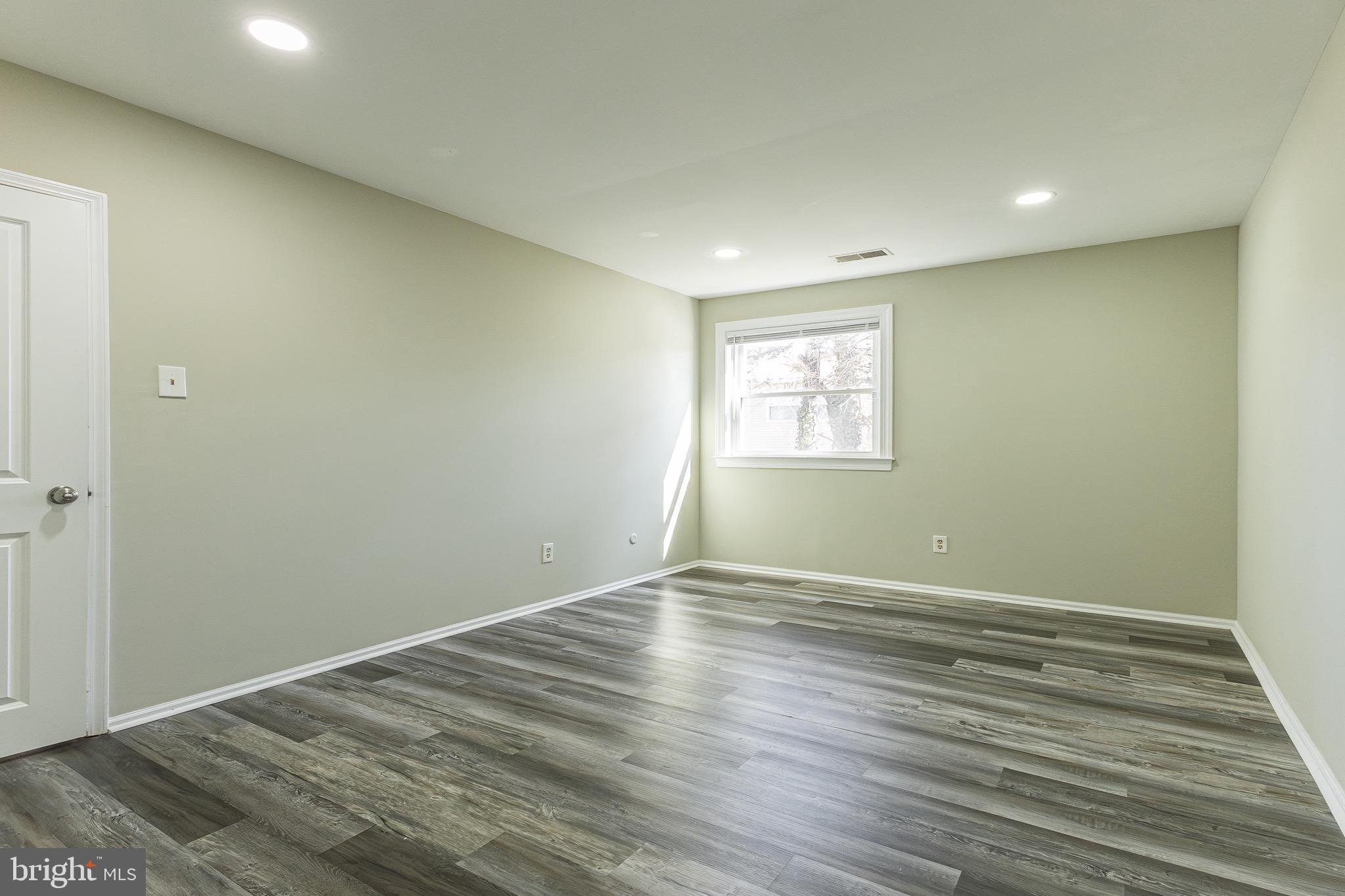 9463 Ashton Road, Unit 1 Philadelphia, PA 19114 - Photo 18 of 25 a view of an empty room with wooden floor and a window