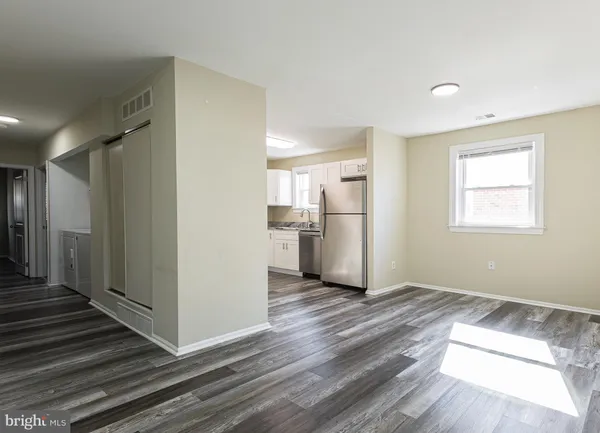 a view of a kitchen with wooden floor and a hallway