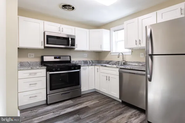 a kitchen with white cabinets and stainless steel appliances