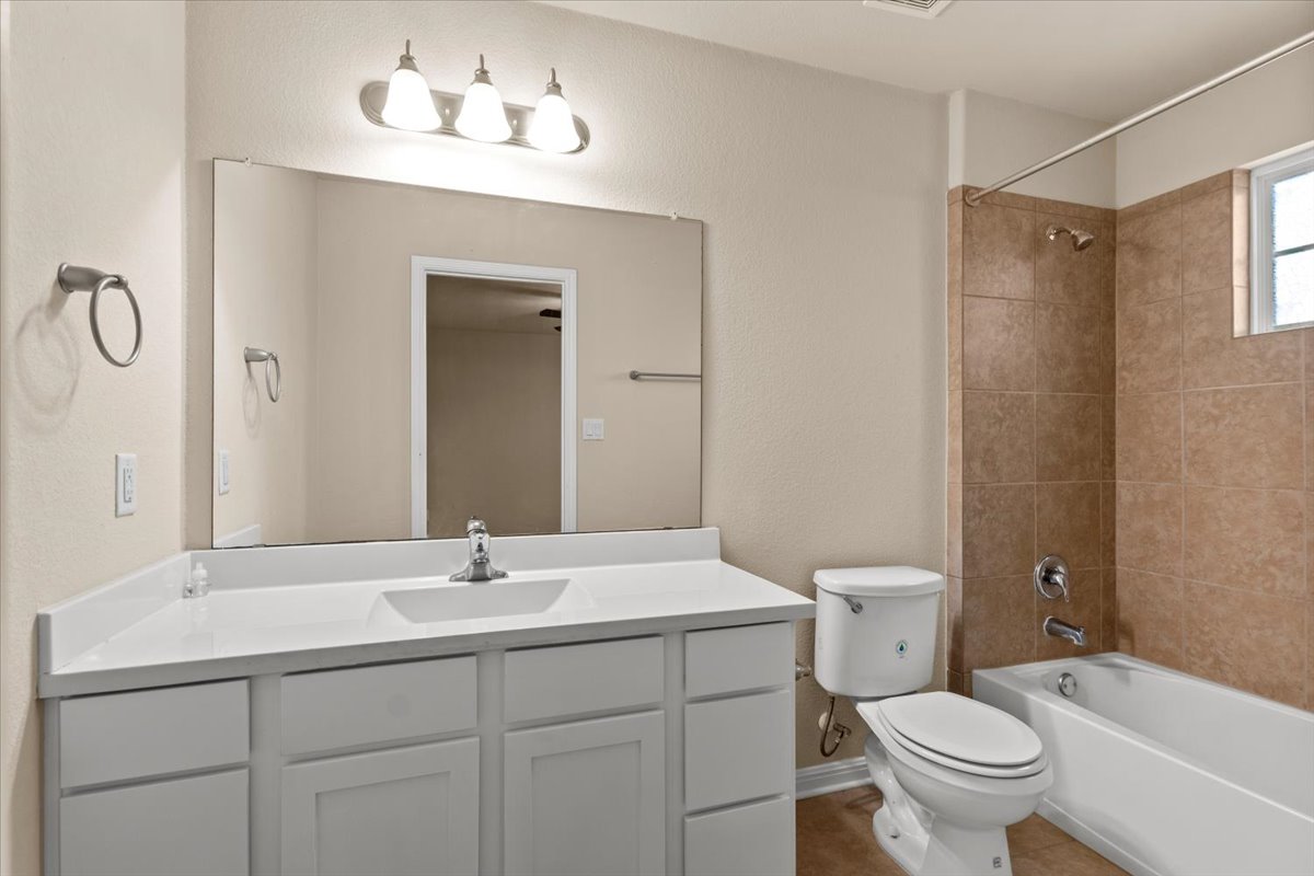 3451 Mayfield Ranch Boulevard, Unit 311 Round Rock, TX 78681 - Photo 33 of 40 Bathroom featuring a white vanity with an integrated sink, brushed nickel faucet, large mirror, and a three-light vanity fixture