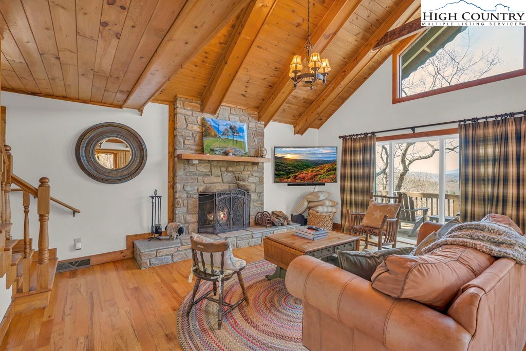 198 Laurel Hill Lane Boone, NC 28607 - Photo 12 of 50 a living room with furniture a fireplace a clock and a large window