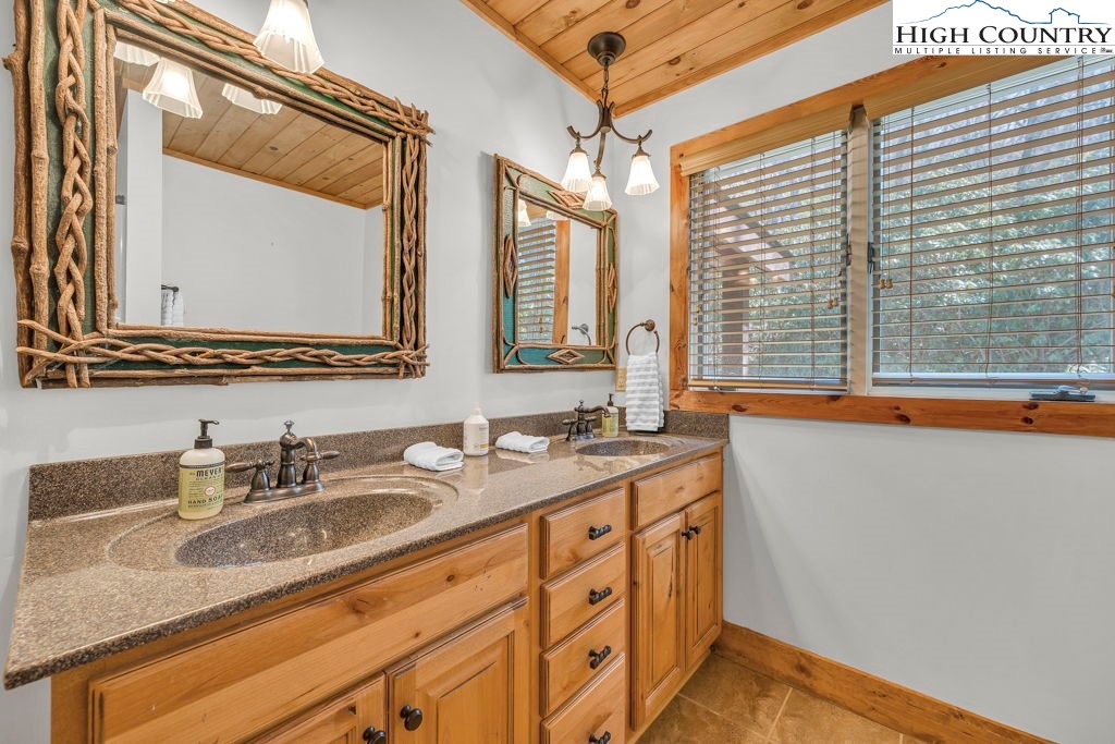 198 Laurel Hill Lane Boone, NC 28607 - Photo 30 of 50 a bathroom with a granite countertop sink and a large mirror