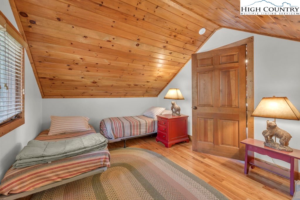 198 Laurel Hill Lane Boone, NC 28607 - Photo 35 of 50 a bedroom with a bed and a chandelier