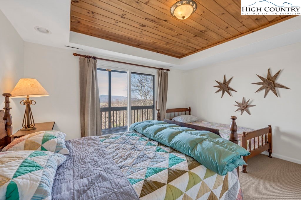 198 Laurel Hill Lane Boone, NC 28607 - Photo 43 of 50 a bedroom with a bed and a chandelier